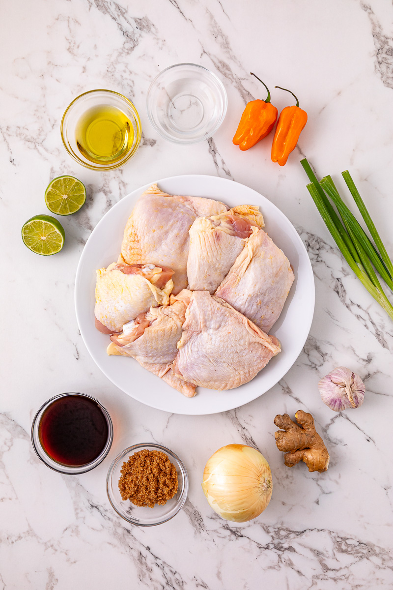 Ingredients for slow cooker jerk chicken thighs laid out on kitchen counter in small bowls.
