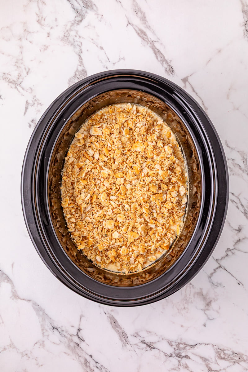 Ritz cracker mixture is sprinkled on top of chicken.