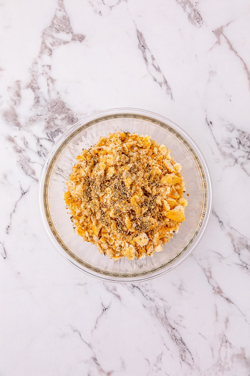 Crumbled Ritz crackers and Italian seasoning are added to the bowl with the melted butter and combined.