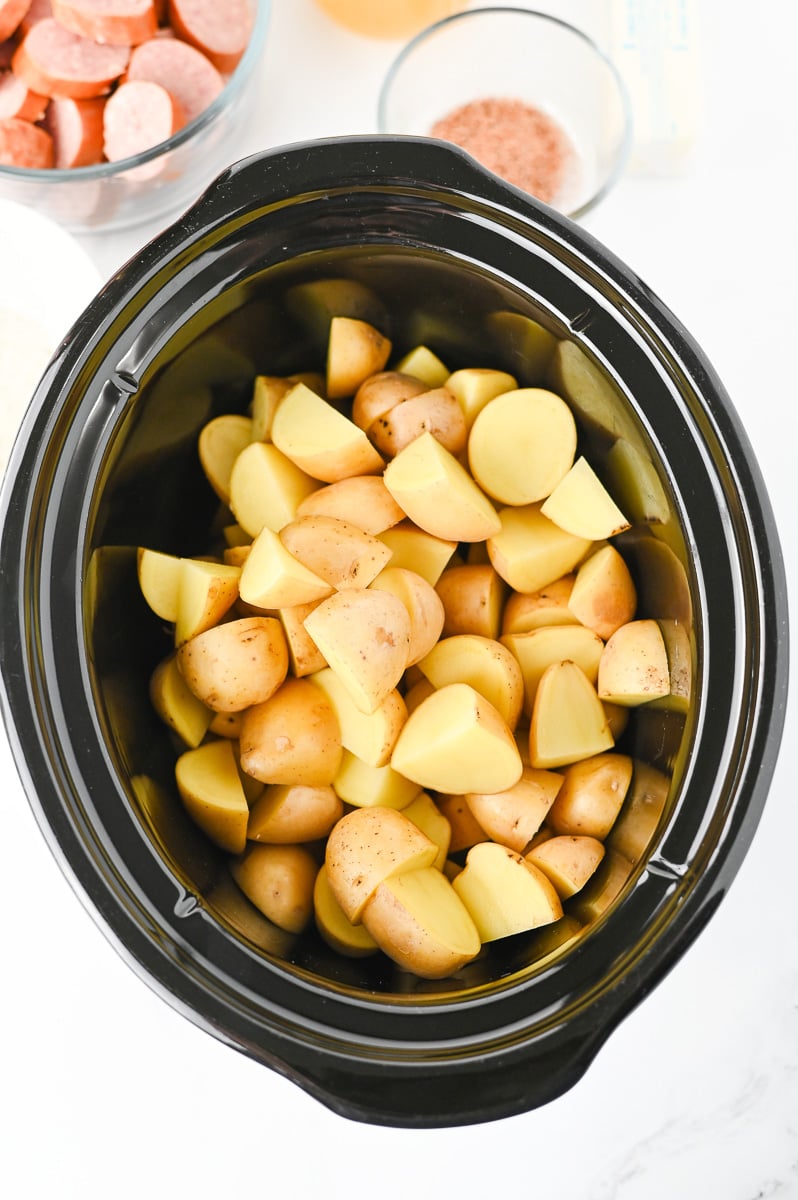 Potatoes are placed in the bottom of the crockpot.