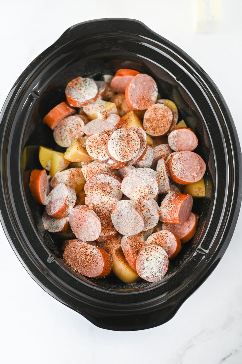 Ranch dressing mix is added to the top of the sausage and potato mixture in crockpot.
