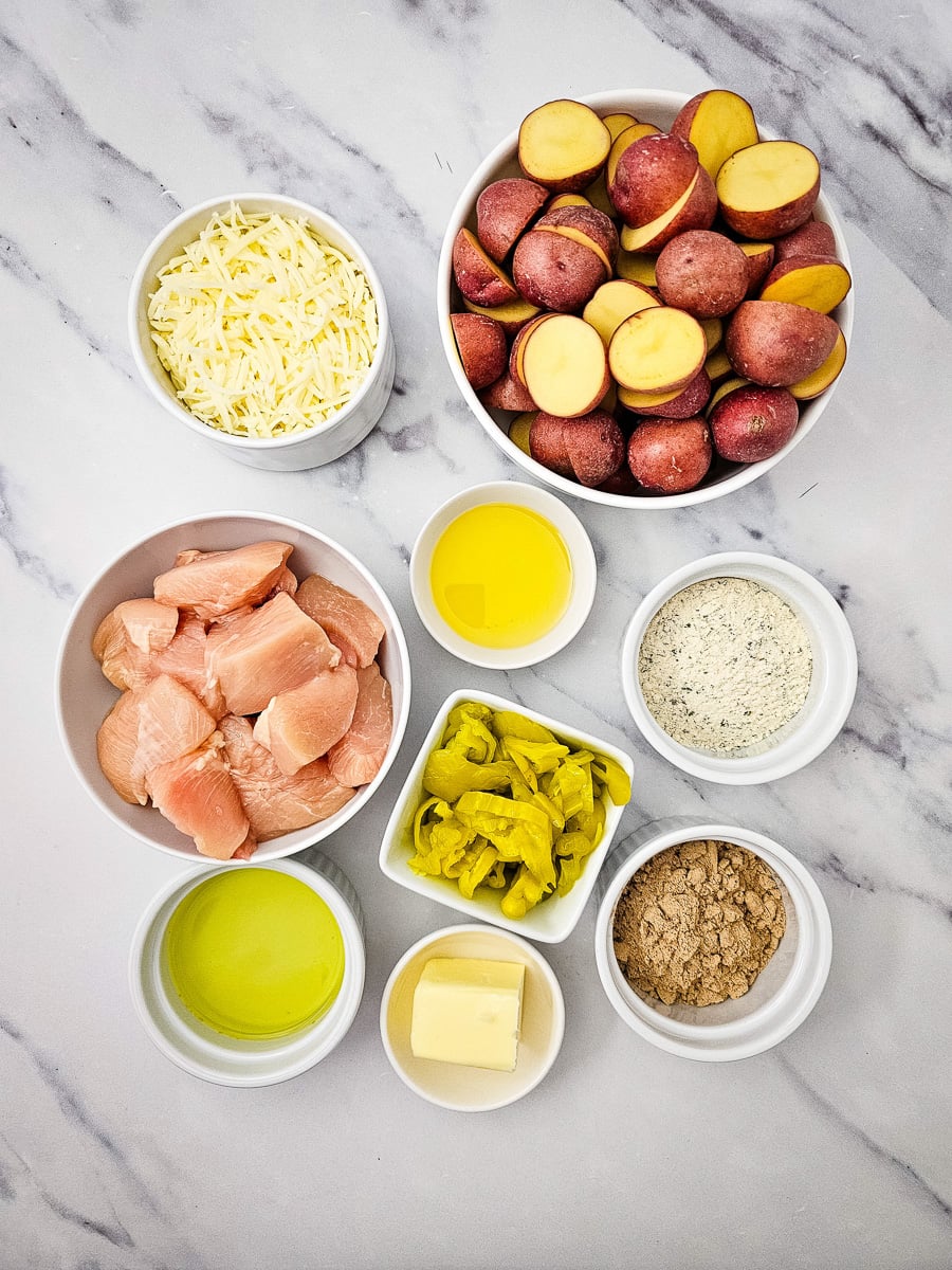 Ingredients for sheet pan Mississippi chicken in small bowls on kitchen counter in preparation for the recipe.