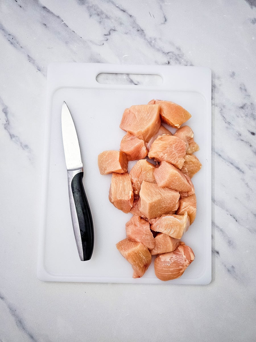 Cubed chicken on cutting board.