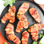 Air fryer bacon wrapped jalapeno poppers served on a plate.