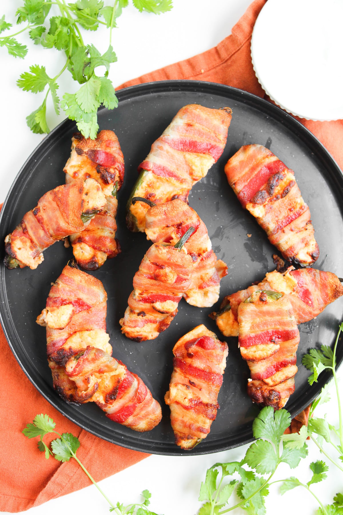 Air fryer bacon wrapped jalapeno poppers served on a plate.