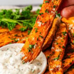 Air fryer sweet potato fries dipped into sauce.