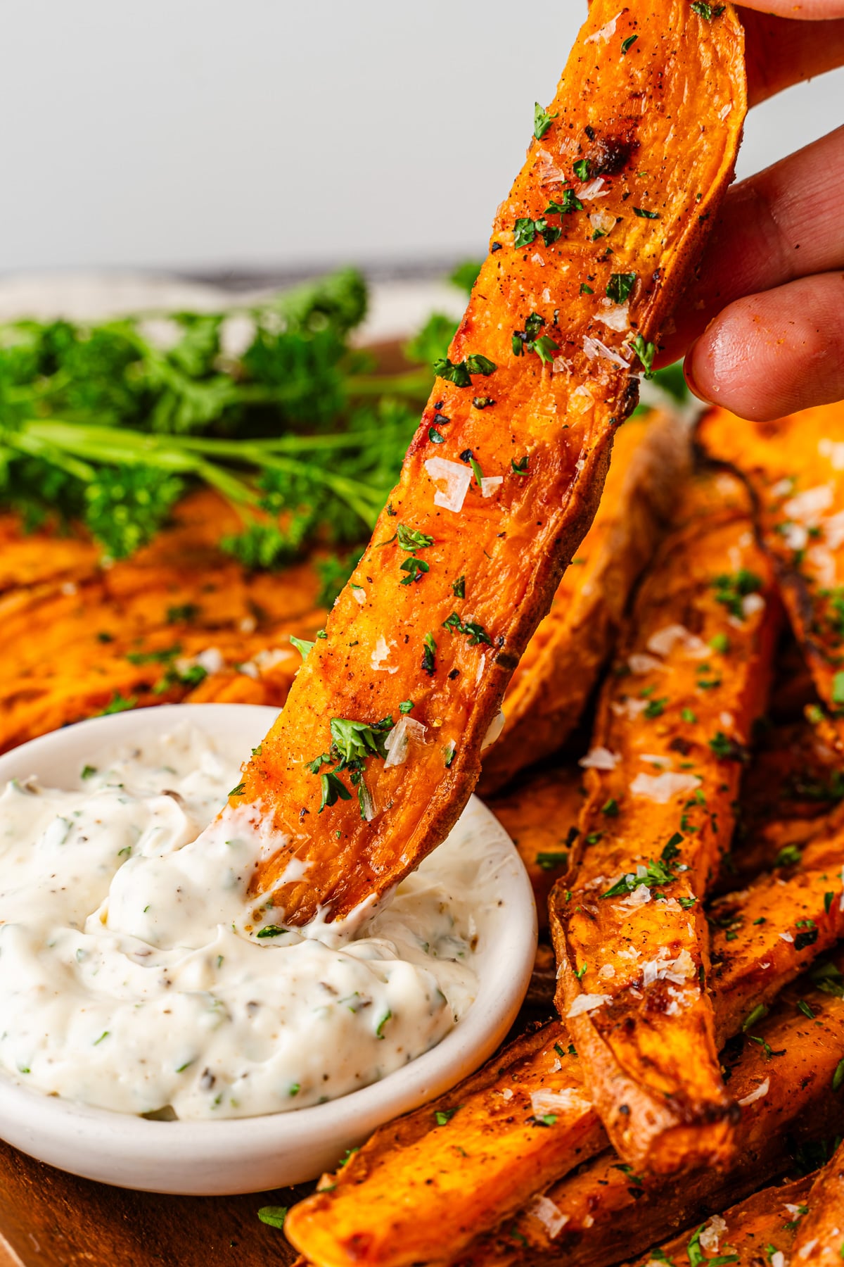 Air fryer sweet potato fries dipped into sauce.
