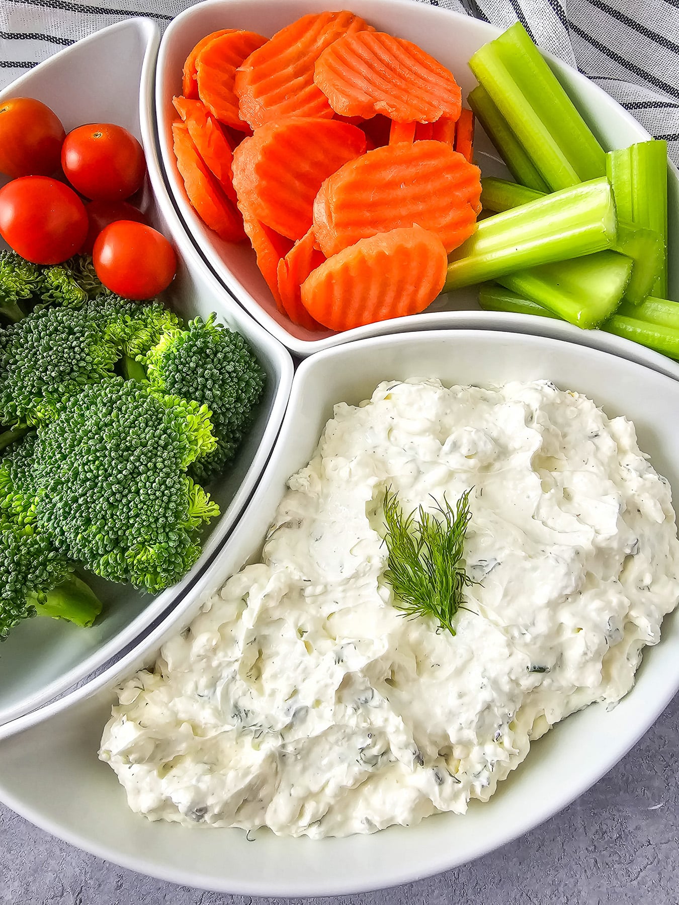 Cream cheese dip served in platter with fresh veggies on the side.