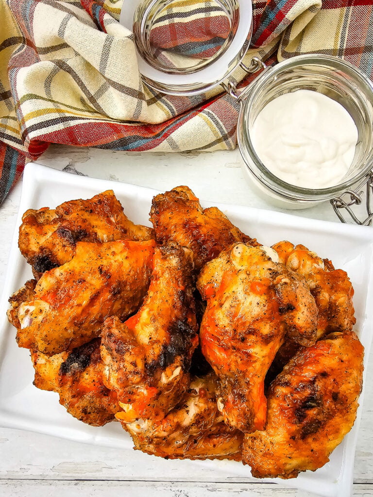 Grilled buffalo chicken wings on a white plate.