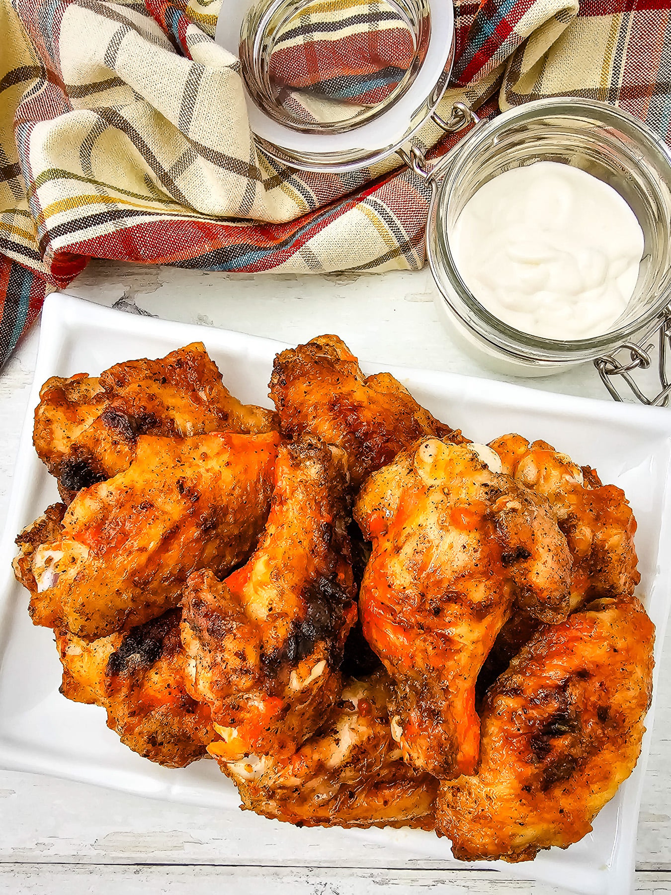 Crispy grilled buffalo chicken wings served on a plate for a football party.