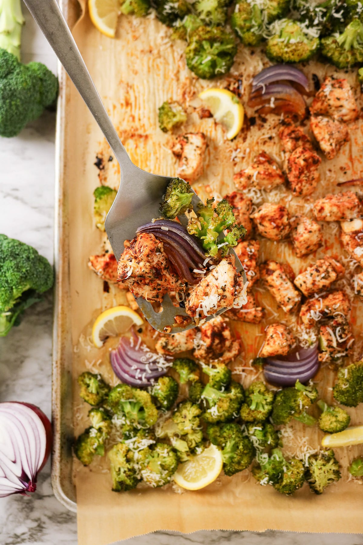 Sheet pan chicken and broccoli on baking sheet ready to be served.