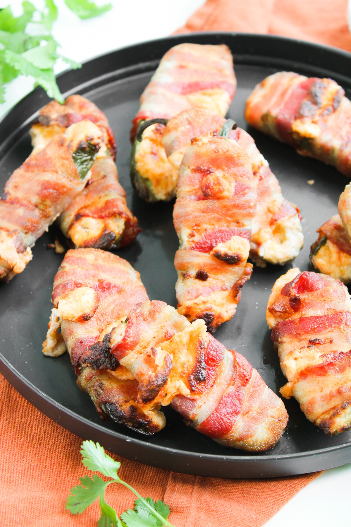 Air fryer bacon wrapped jalapeno poppers served on a plate for a party.