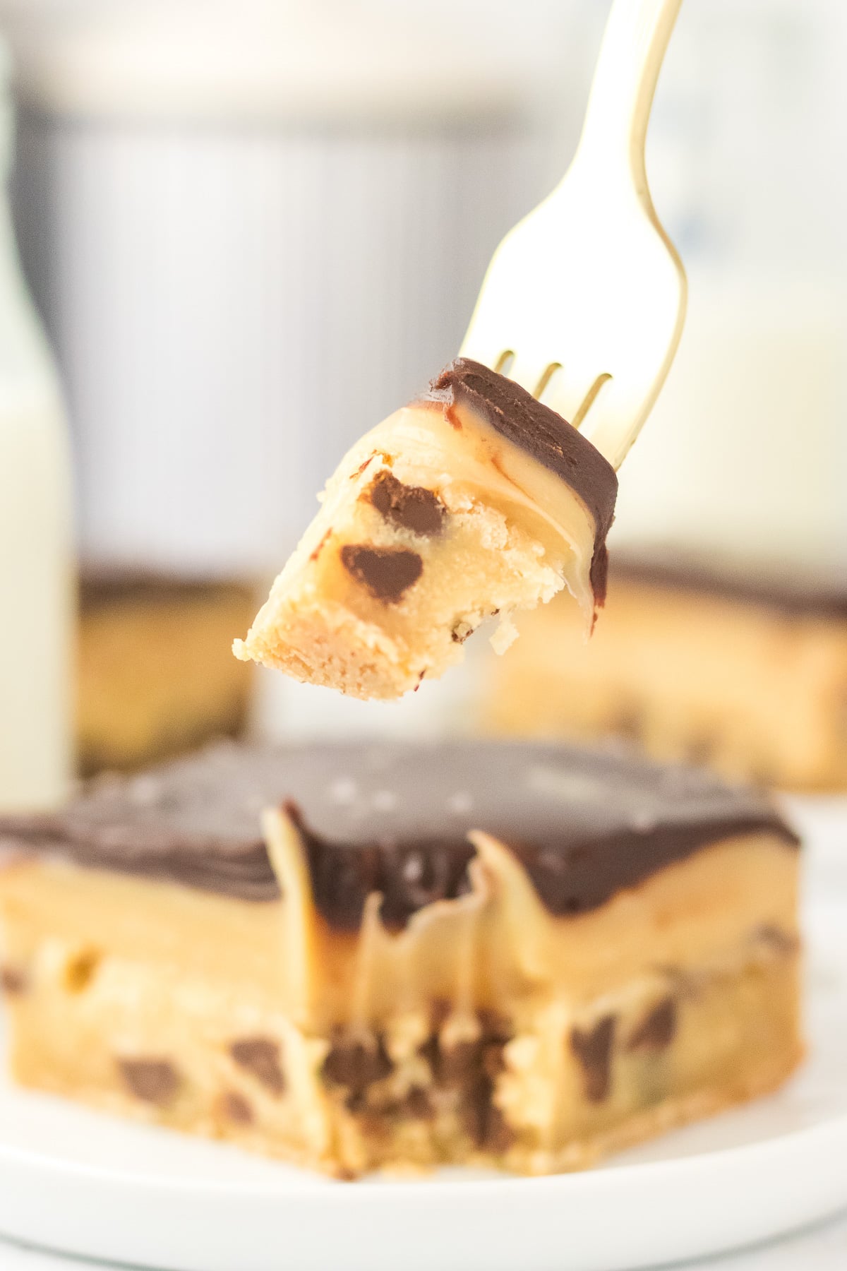 Bite of millionaire bars on fork held over piece on plate.