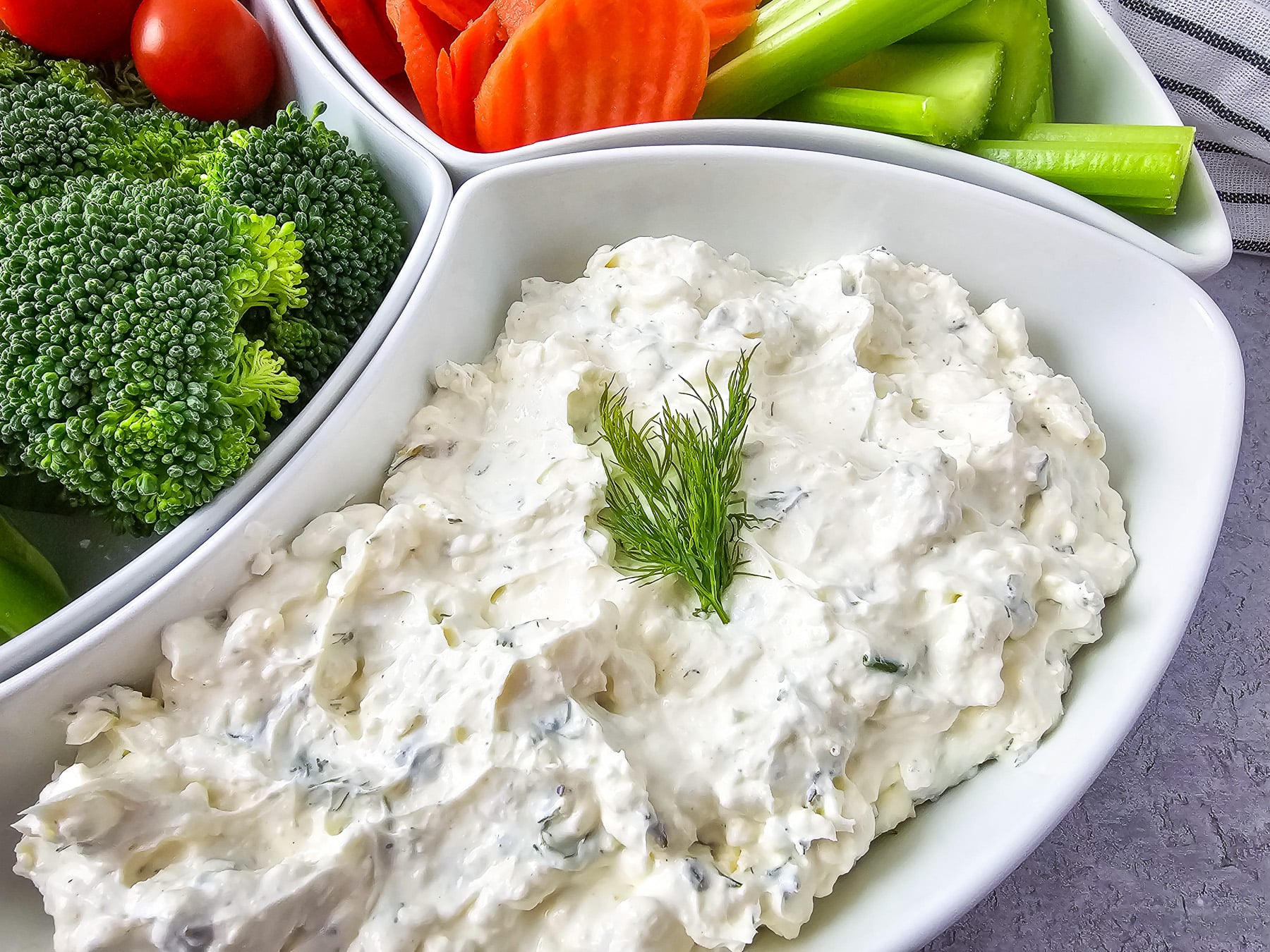 Side view of cream cheese veggie dip in serving bowl.