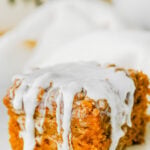 Pumpkin coffee cake with glaze served on a white plate.