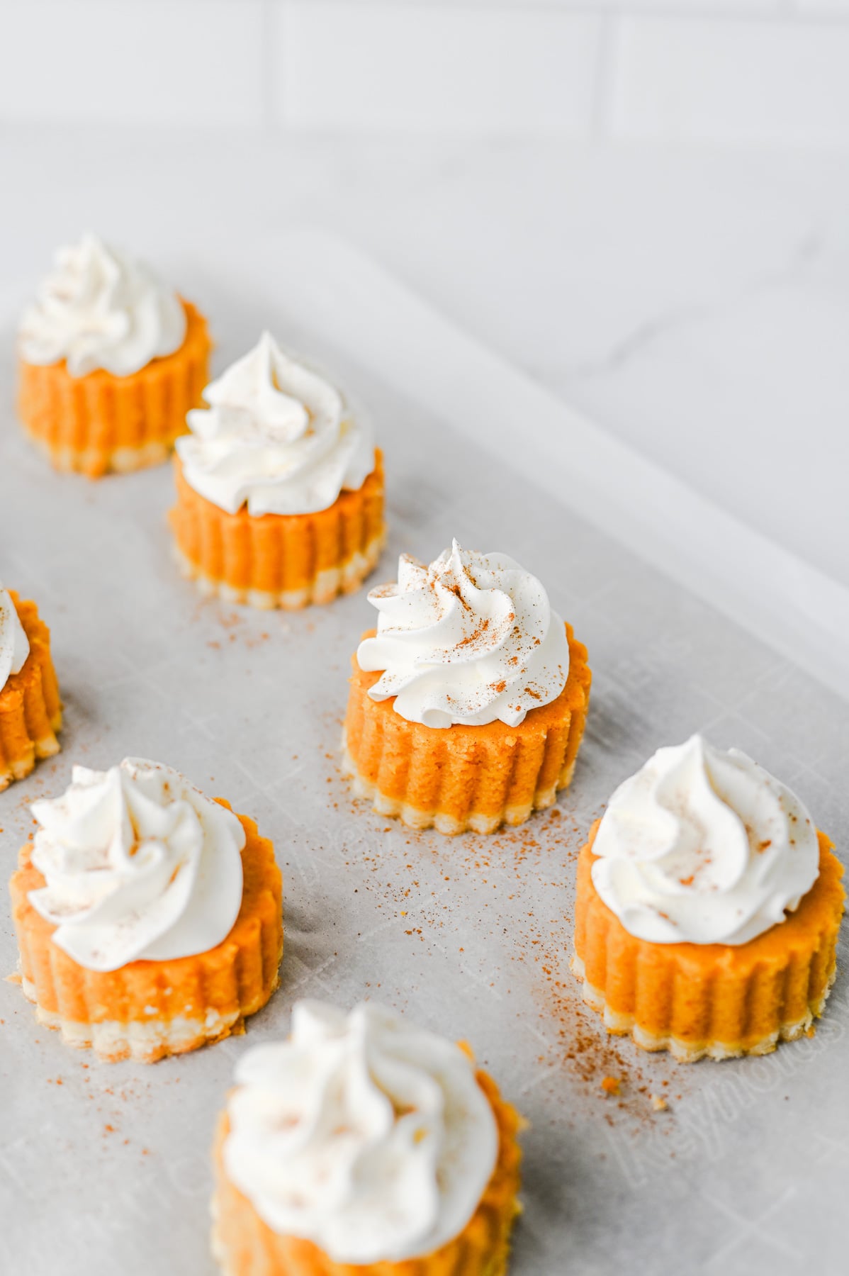 Pumpkin pie bites are topped with Coll Whip and sprinkled with pumpkin pie spice for an easy fall dessert idea.