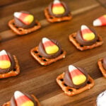 Candy corn pretzel bites on wooden serving tray.