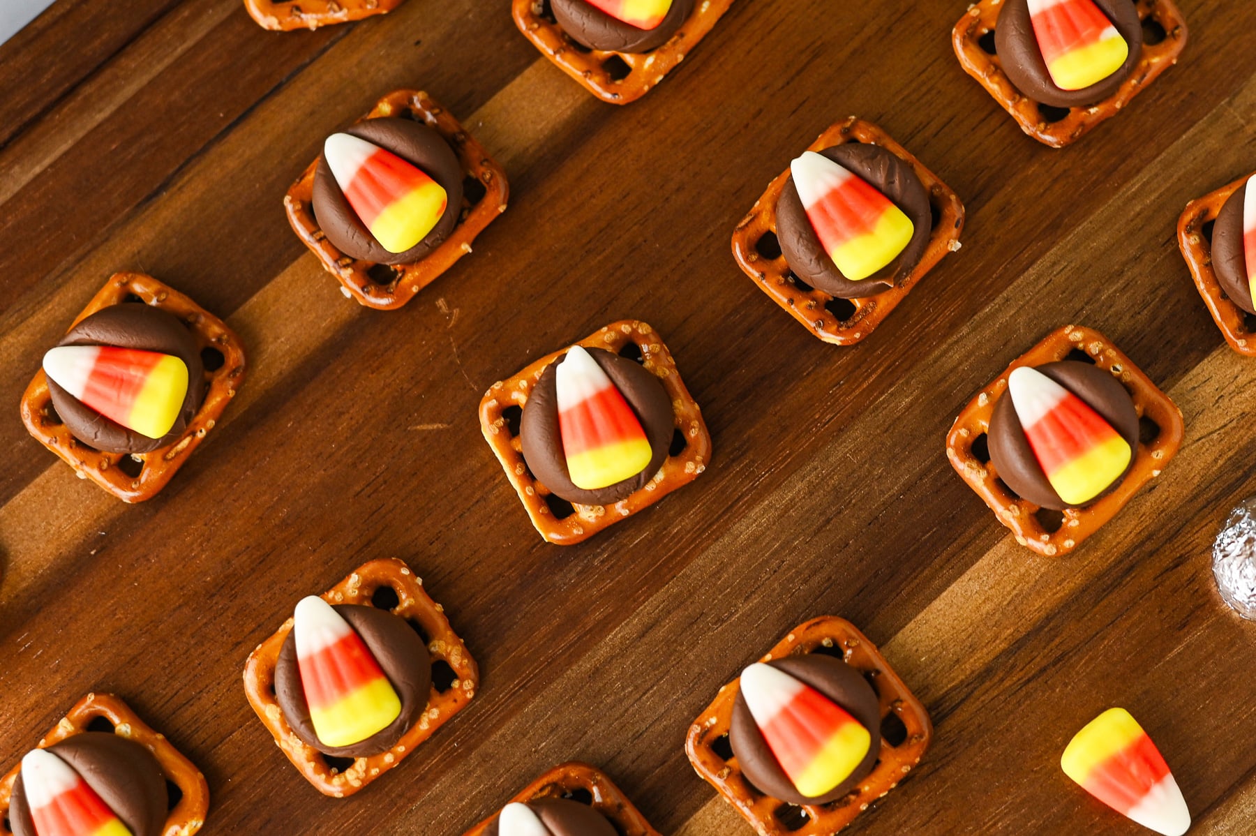 Candy corn pretzel bites on a wooden serving board.