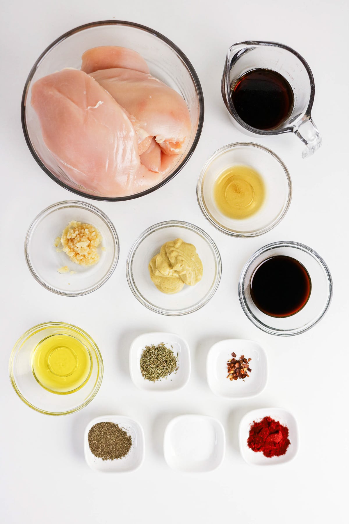 Ingredients for maple glazed chicken in small bowls on kitchen counter.