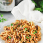 Crockpot beef & noodles on a white plate.