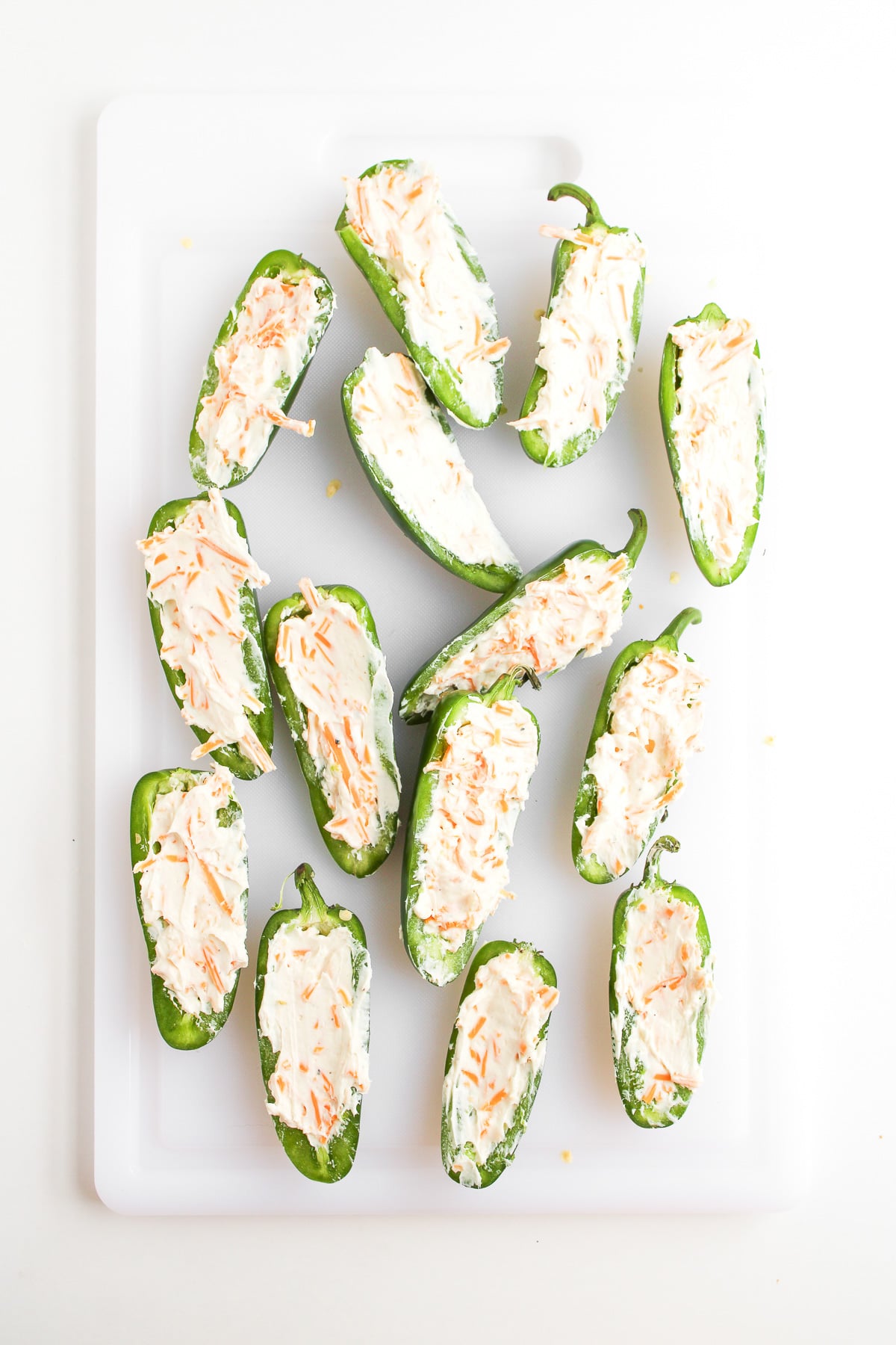 Jalapeno halves are filled with cream cheese mixture.