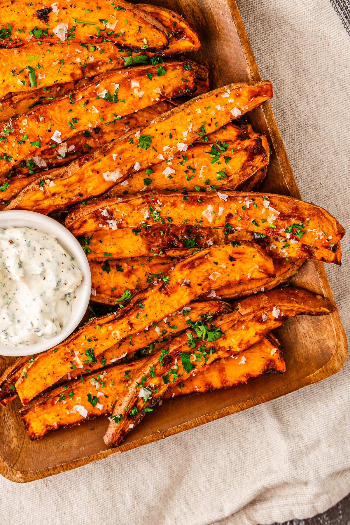 Sweet potato fries arranged on wooden board.