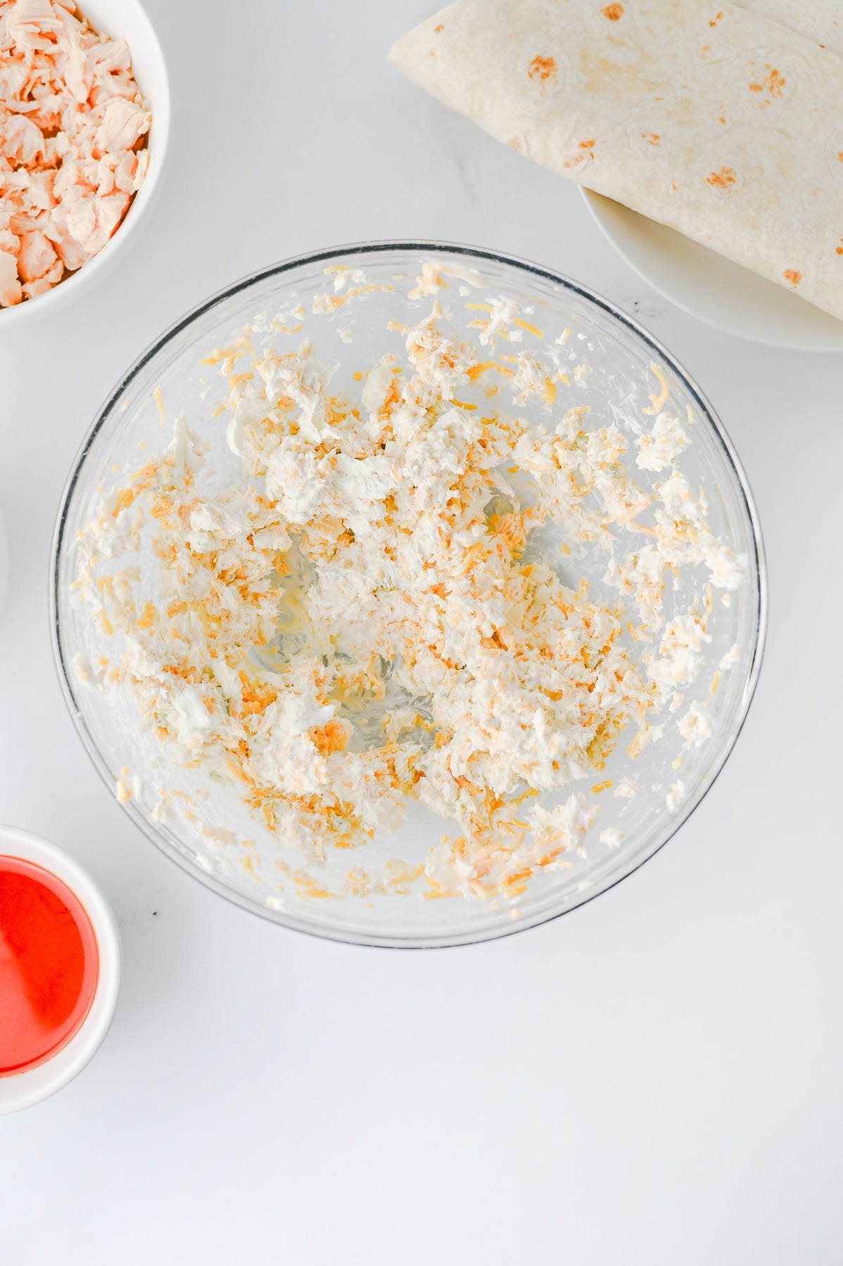 Cream cheese mixture in glass mixing bowl.