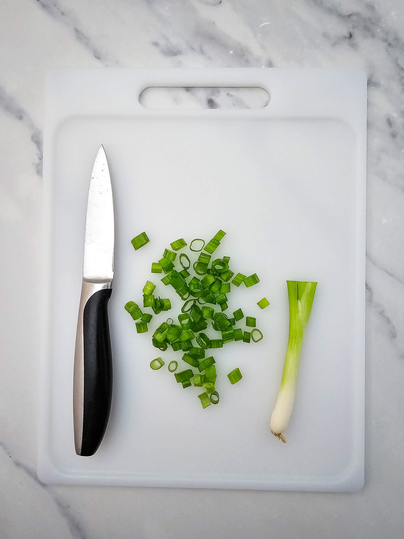 Sliced green onions on cutting board.