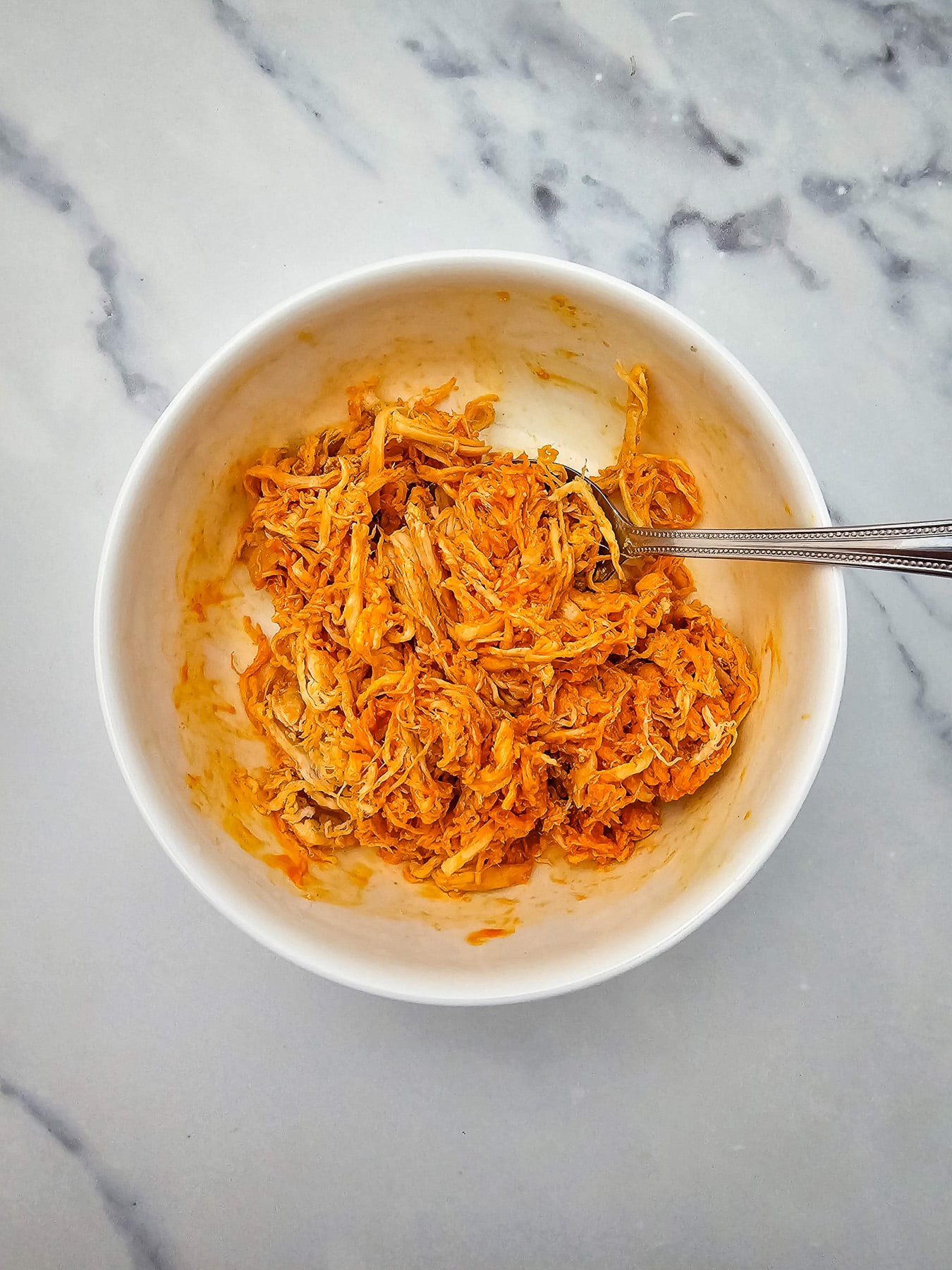 Buffalo chicken mixture in mixing bowl.