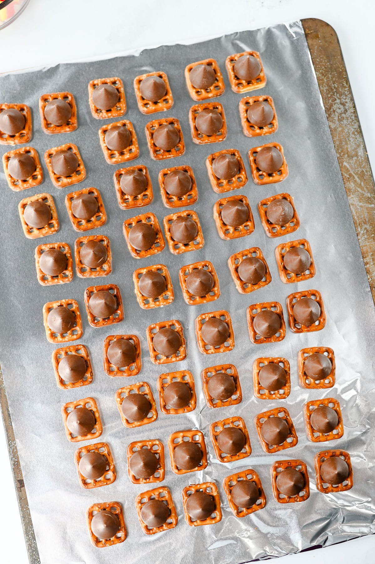 Hershey's kisses are placed on top of the pretzel snaps.