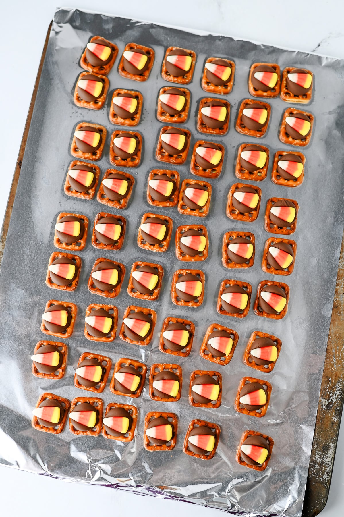 Candy corn candy is pressed into the melted Hershey kisses.