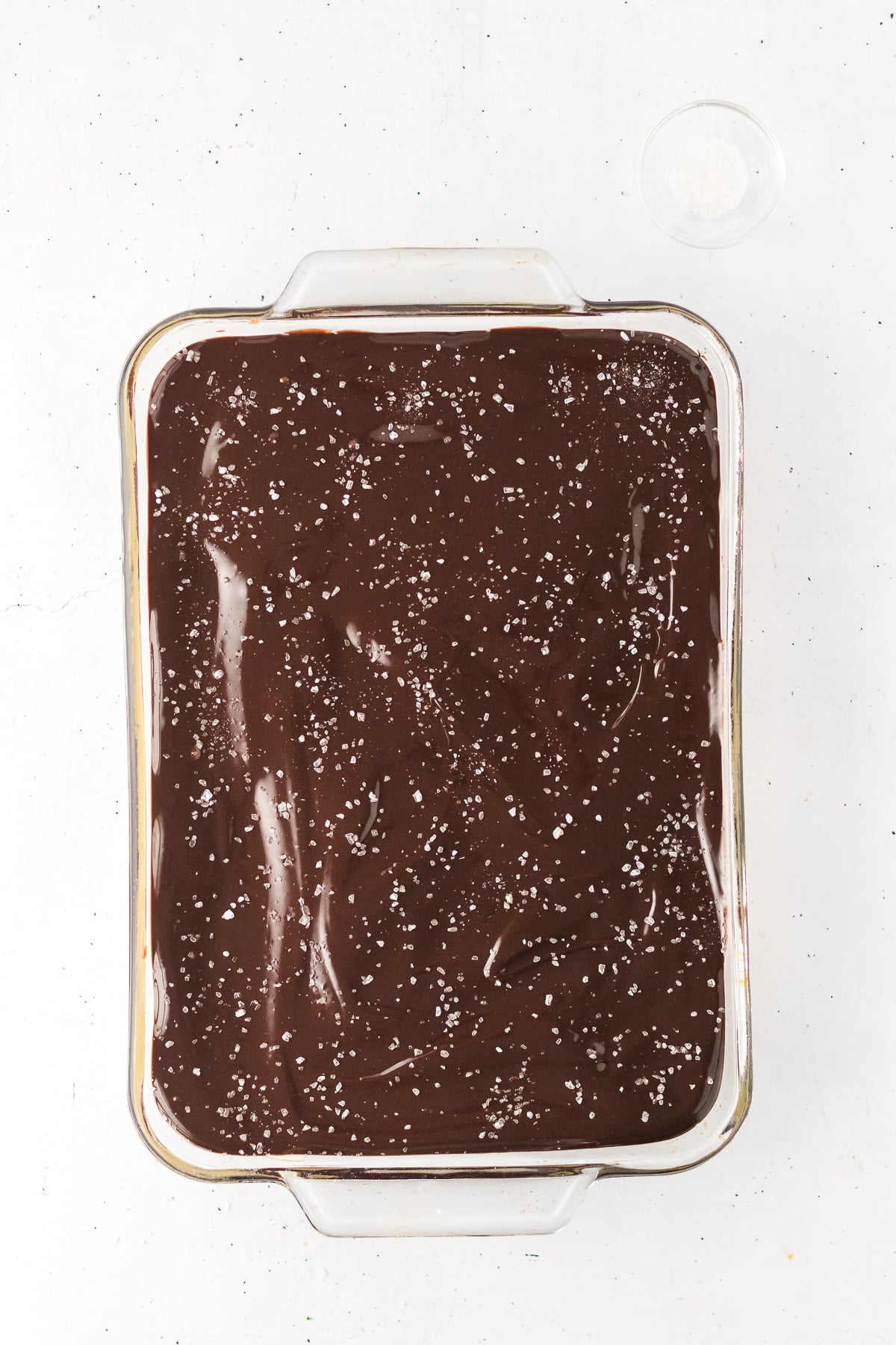 Chocolate ganache is sptread on top of the caramel layer.