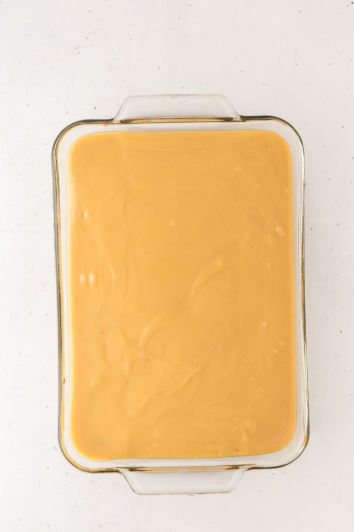 Caramel layer is poured on top of cookie layer.