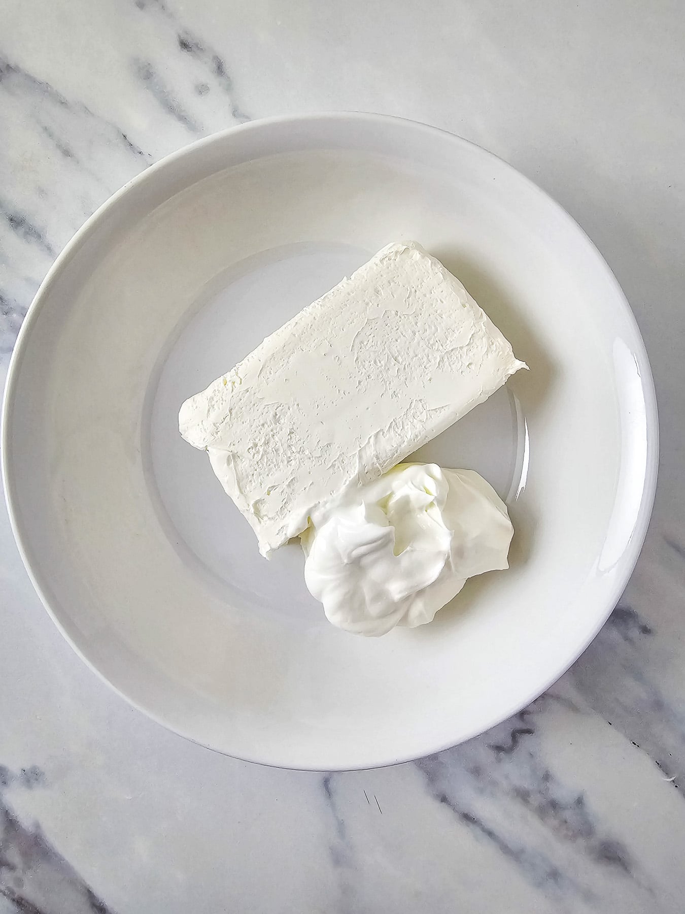 Cream cheese and sour cream in mixing bowl.