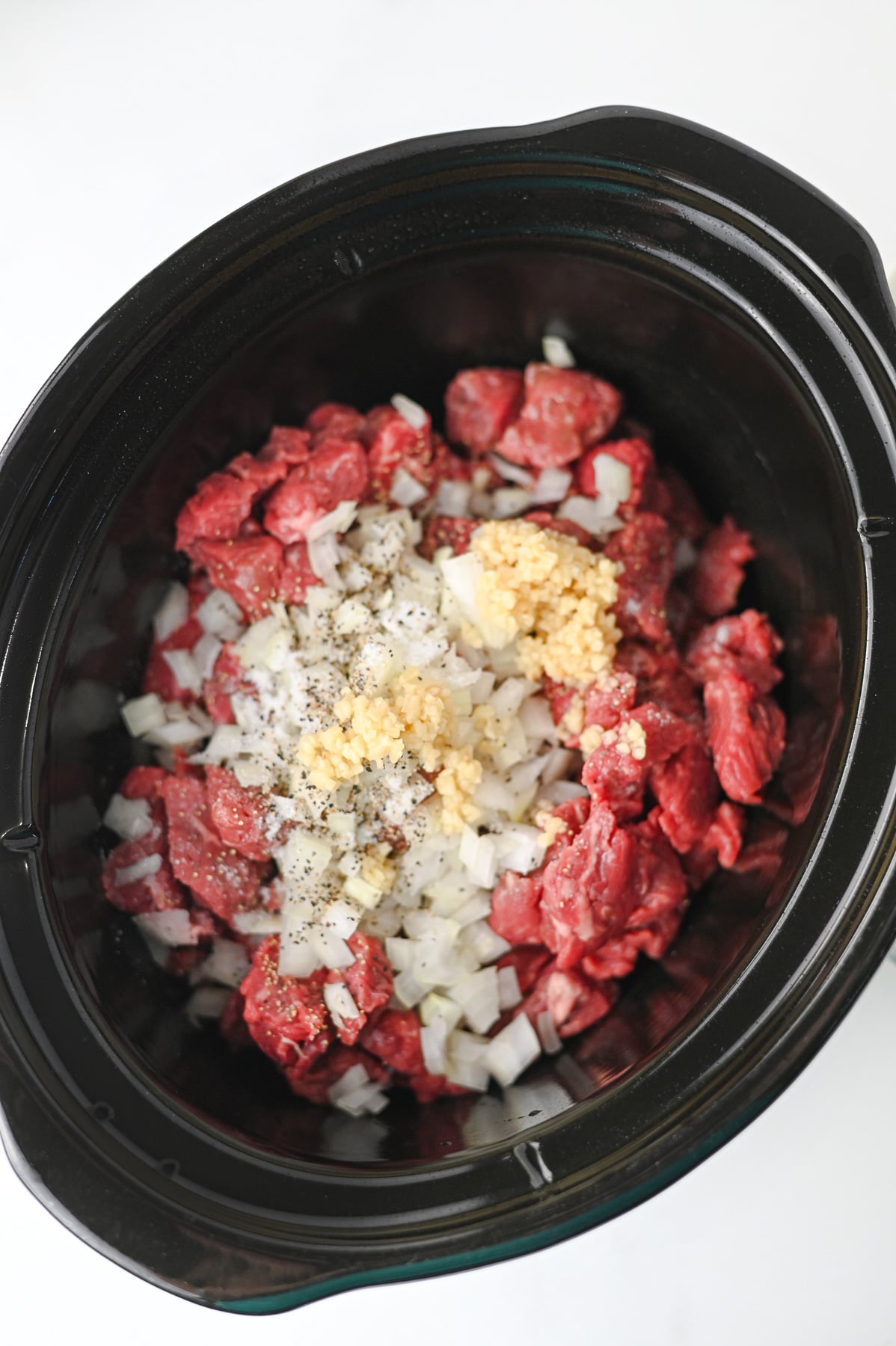 Beef in bottom of crocpot with au just gravy mix, garlic & onions sprinkled on top.