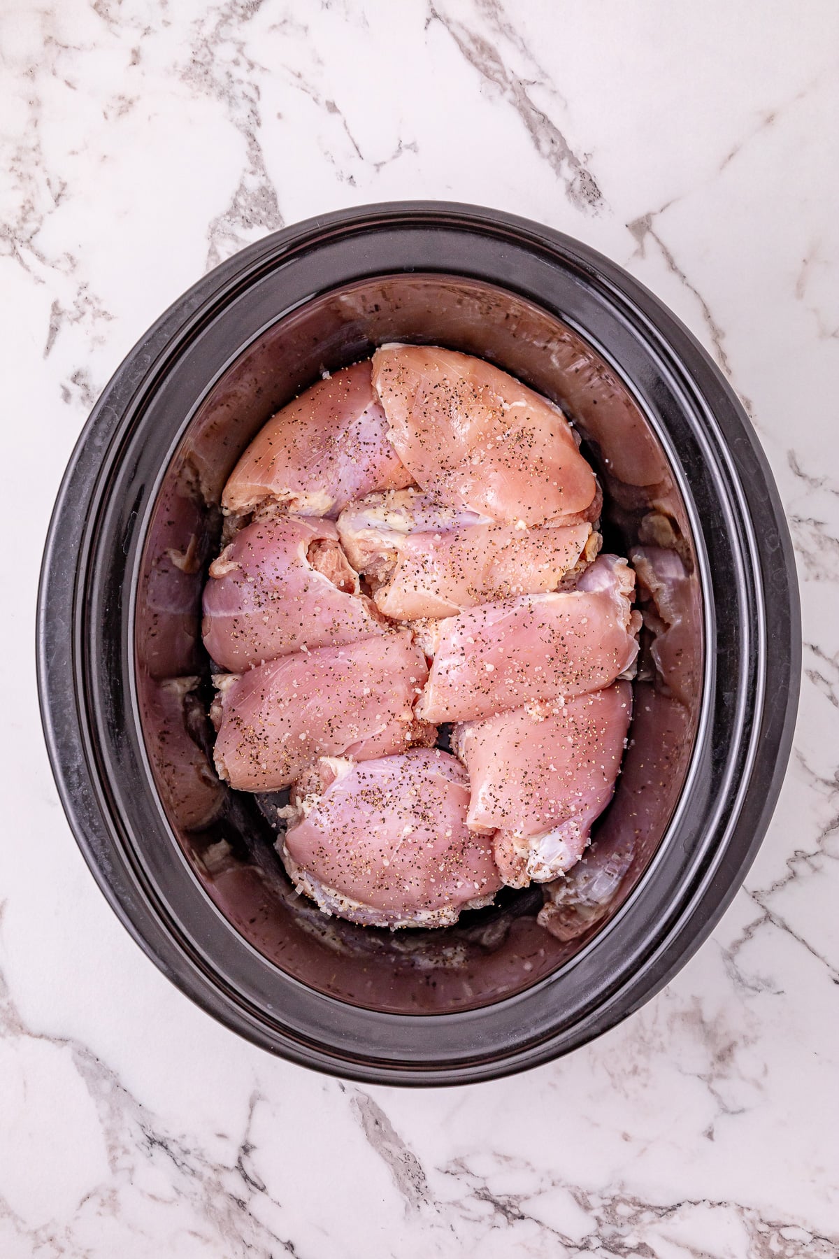 Chicken thighs in bottom of slow cooker.