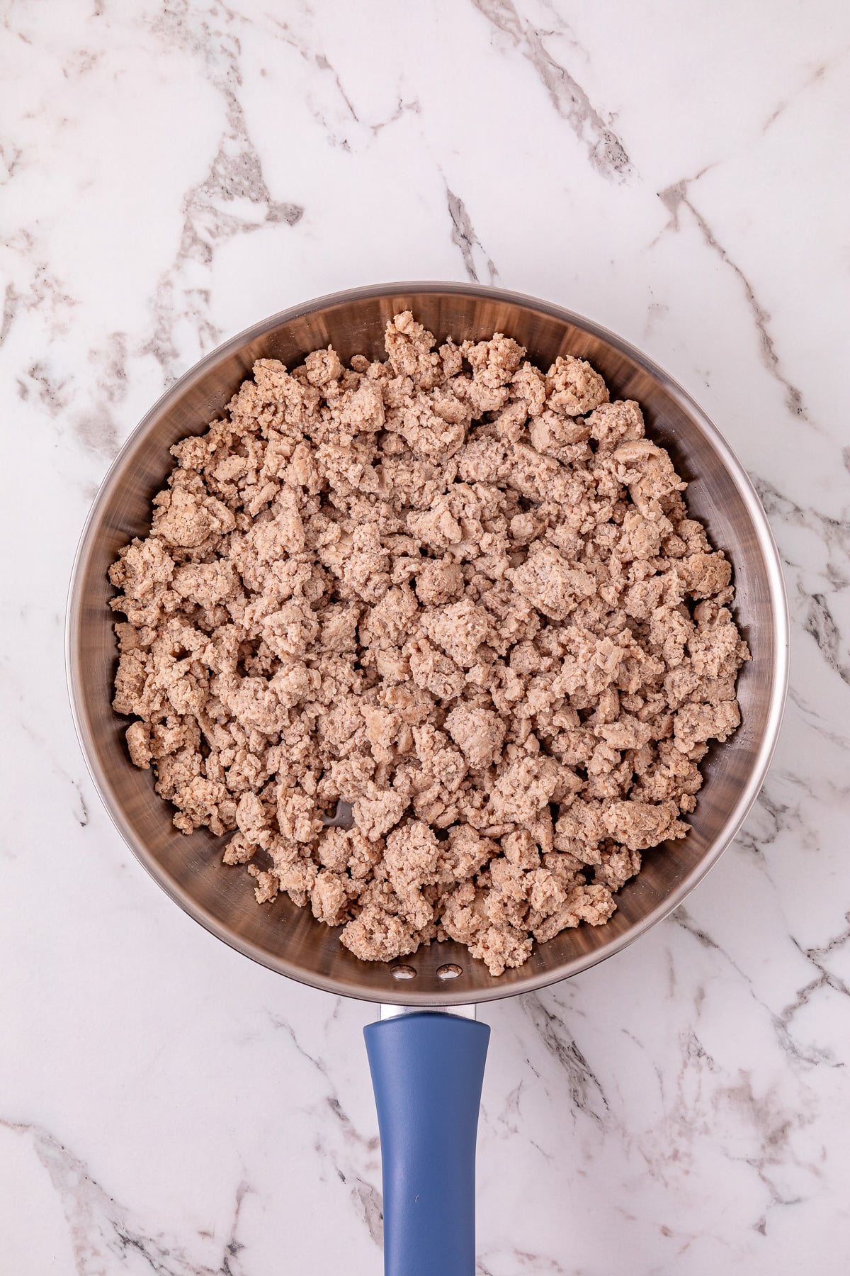 Ground turkey in skillet ready to add to the crockpot.