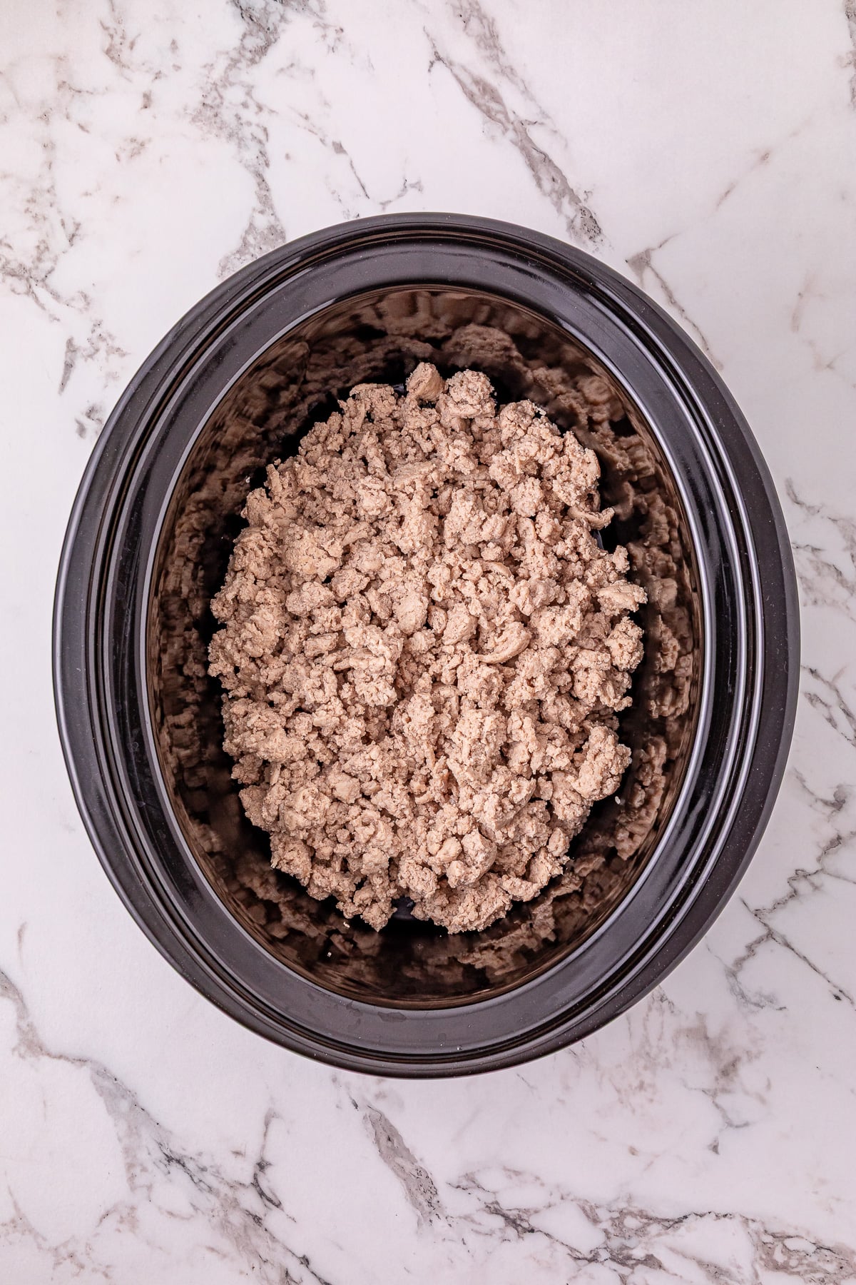 Cooked ground turkey in bottom of crockpot.