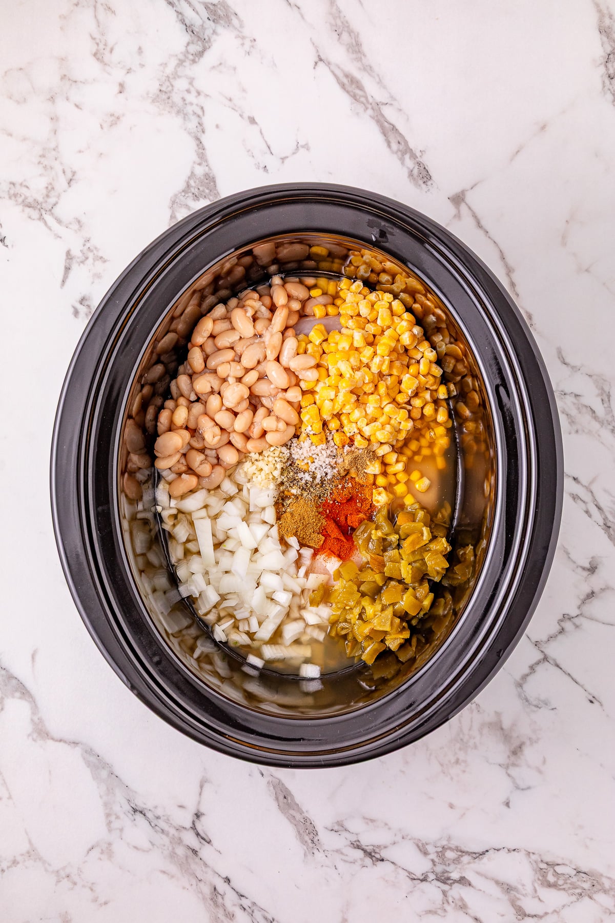 Next set of ingredients is added to the top of chicken in crockpot.