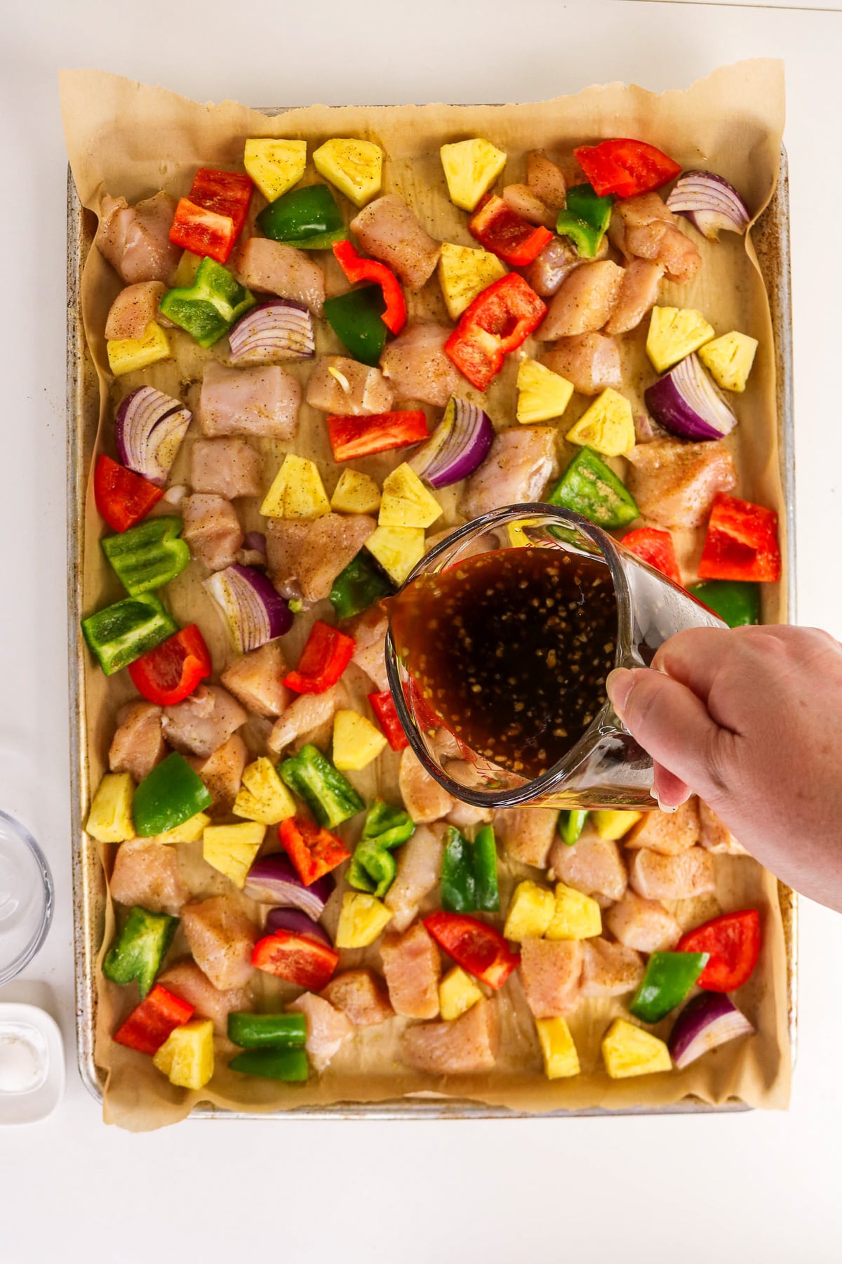 Sauce mixture is poured on top of ingredients on baking pan.