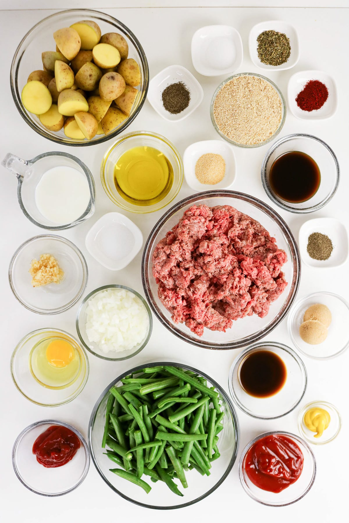 Ingredients for sheet pan meatloaf and potatoes in small bowls on counter to prep for making the recipe.