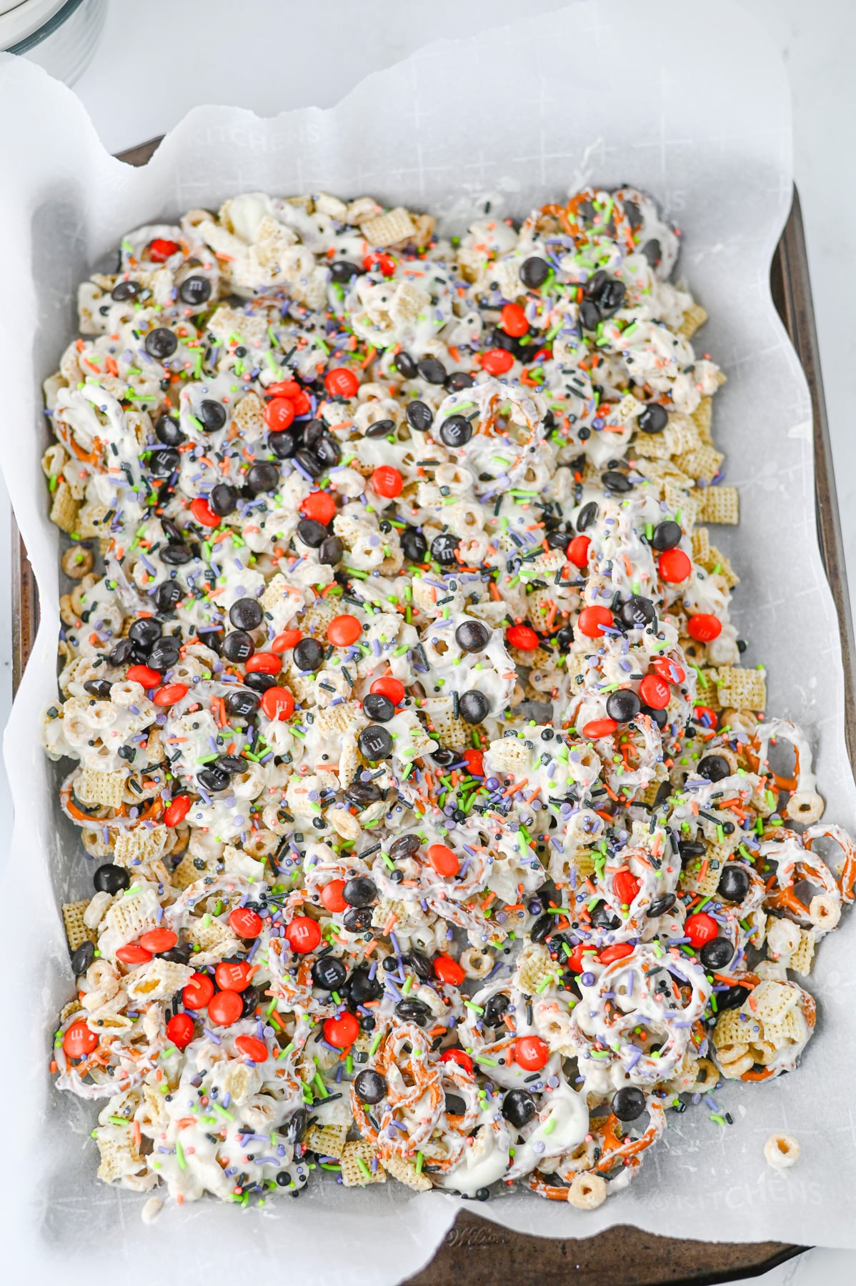 Candies are added to the top of the cereal mixture on baking sheeet.