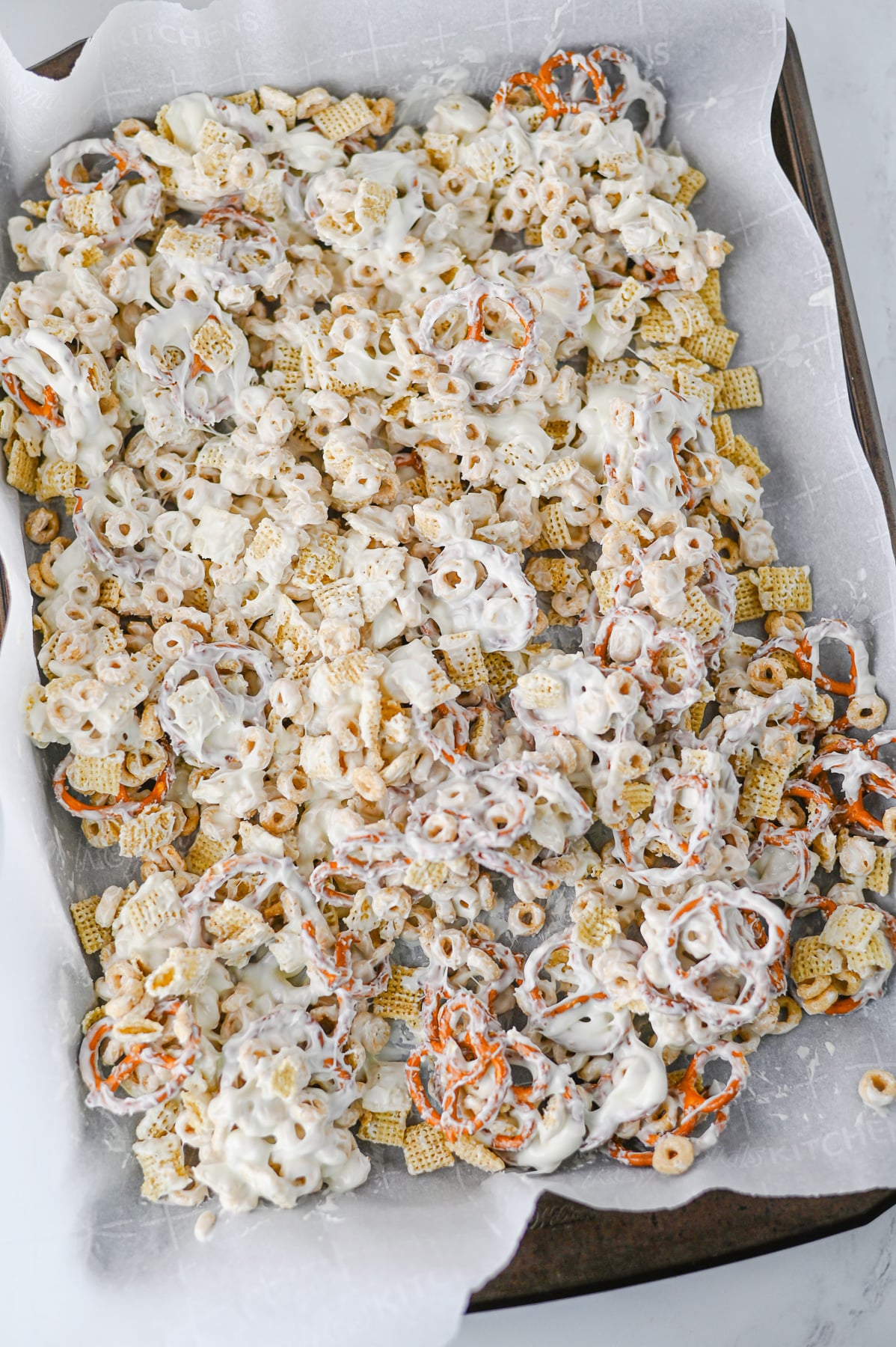 White chocolate mixture is drizzled on top of cereal mixture.