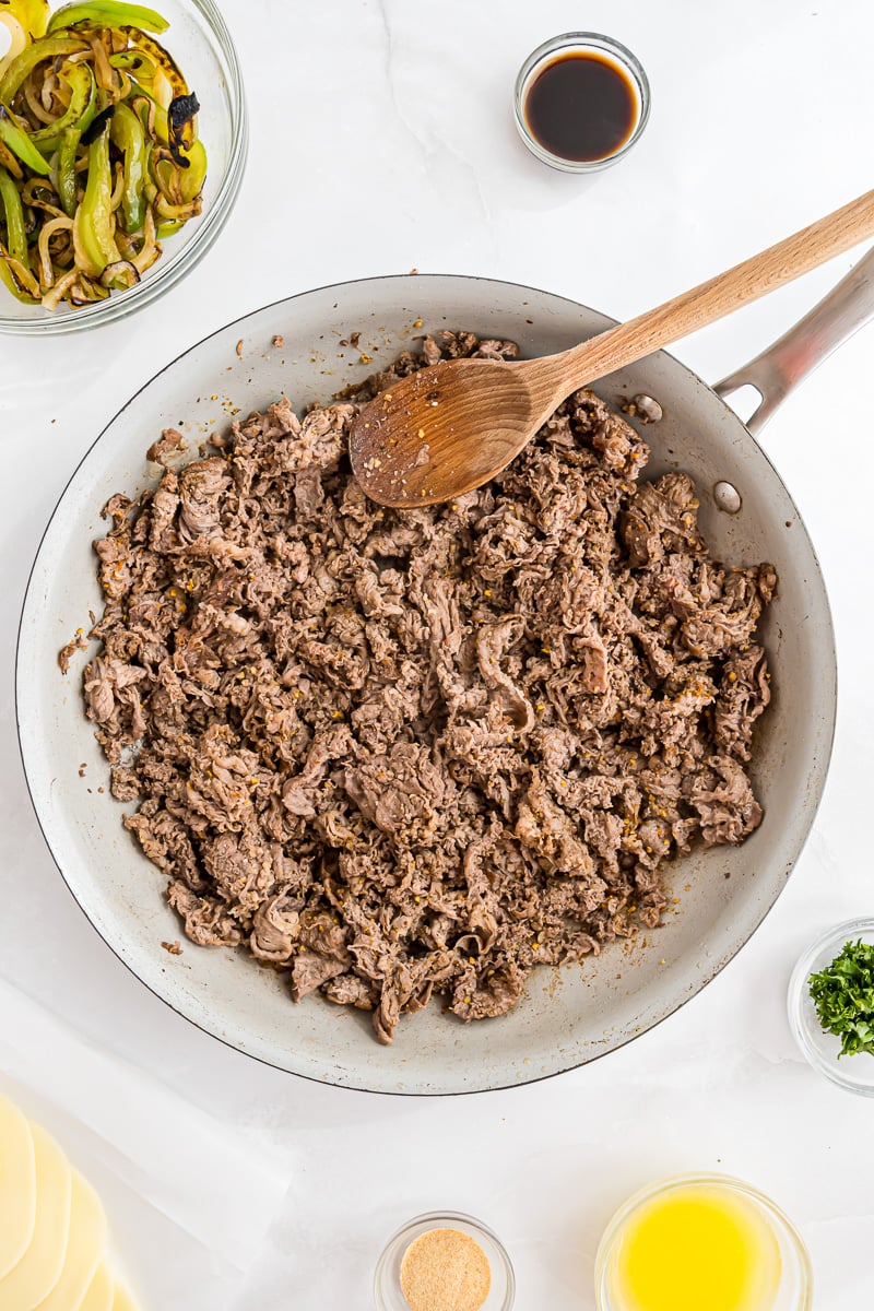 Shaved steak is added to the skillet.