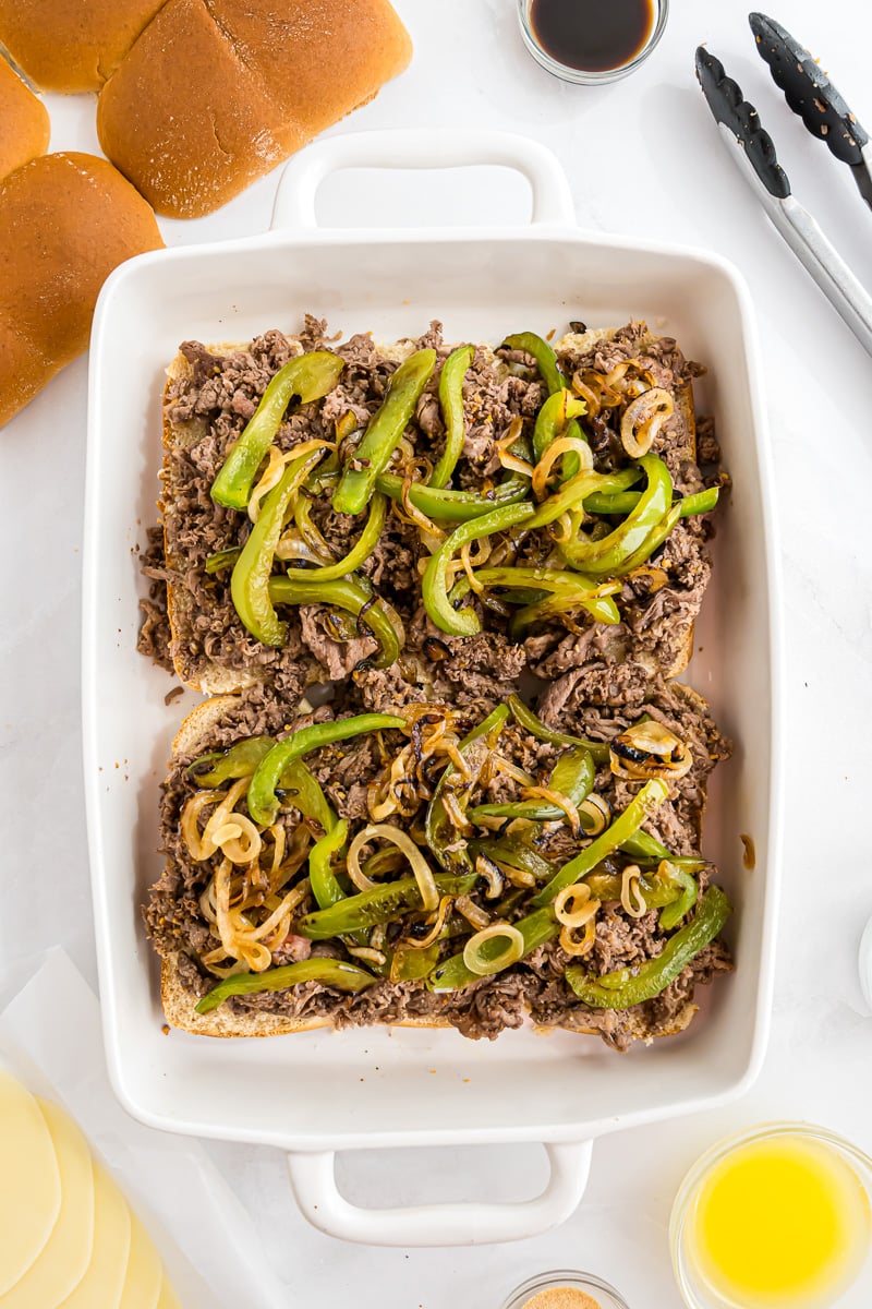 Onion and pepper mixture is added to the top of the sliders.