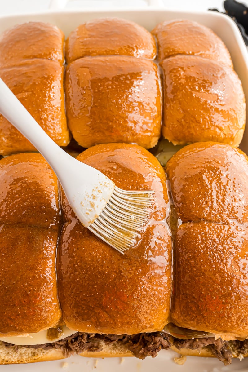 Topping mixture is brushed on top of slider buns.