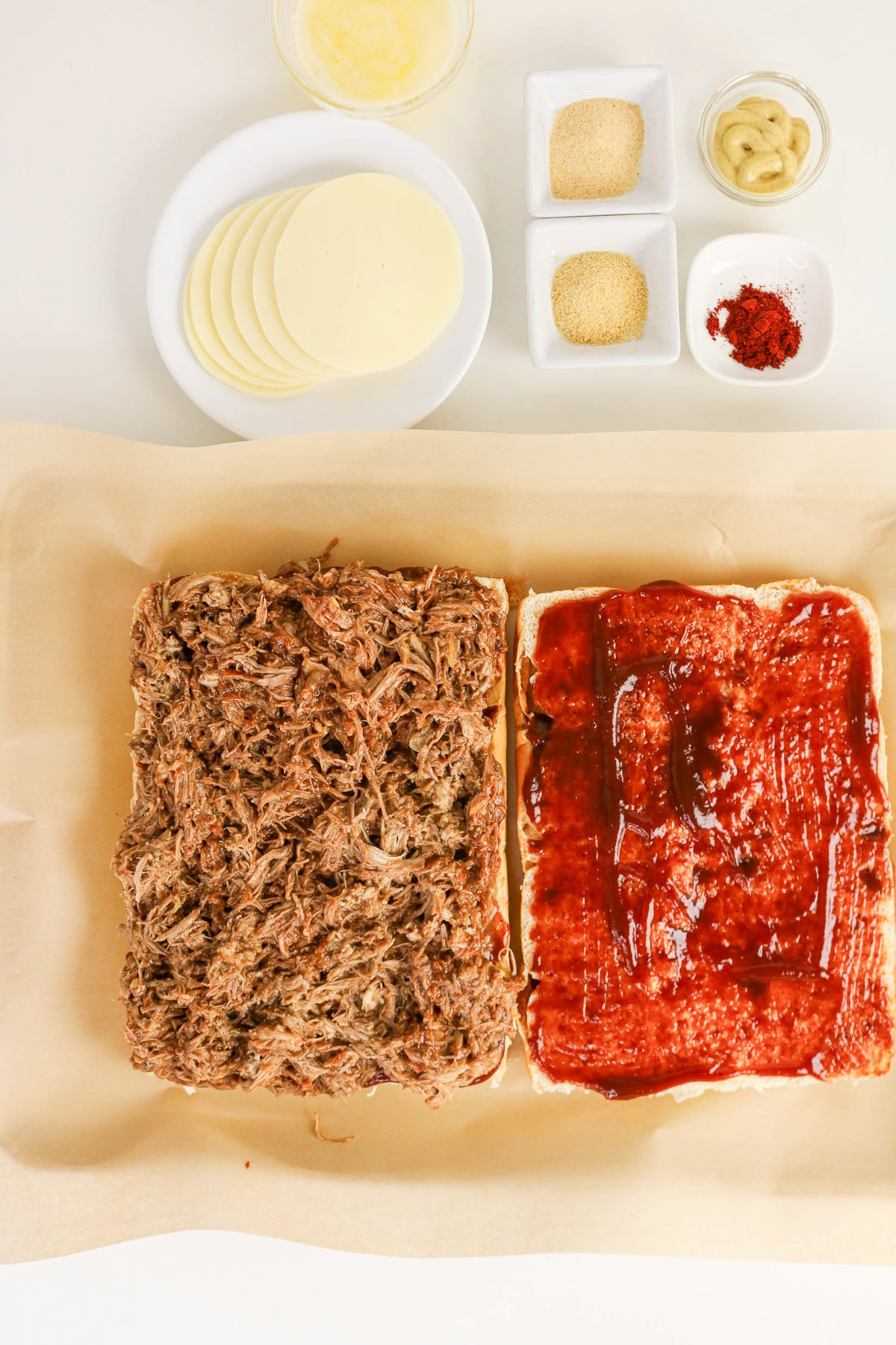 Pulled pork mixture is spread on top of cheese.