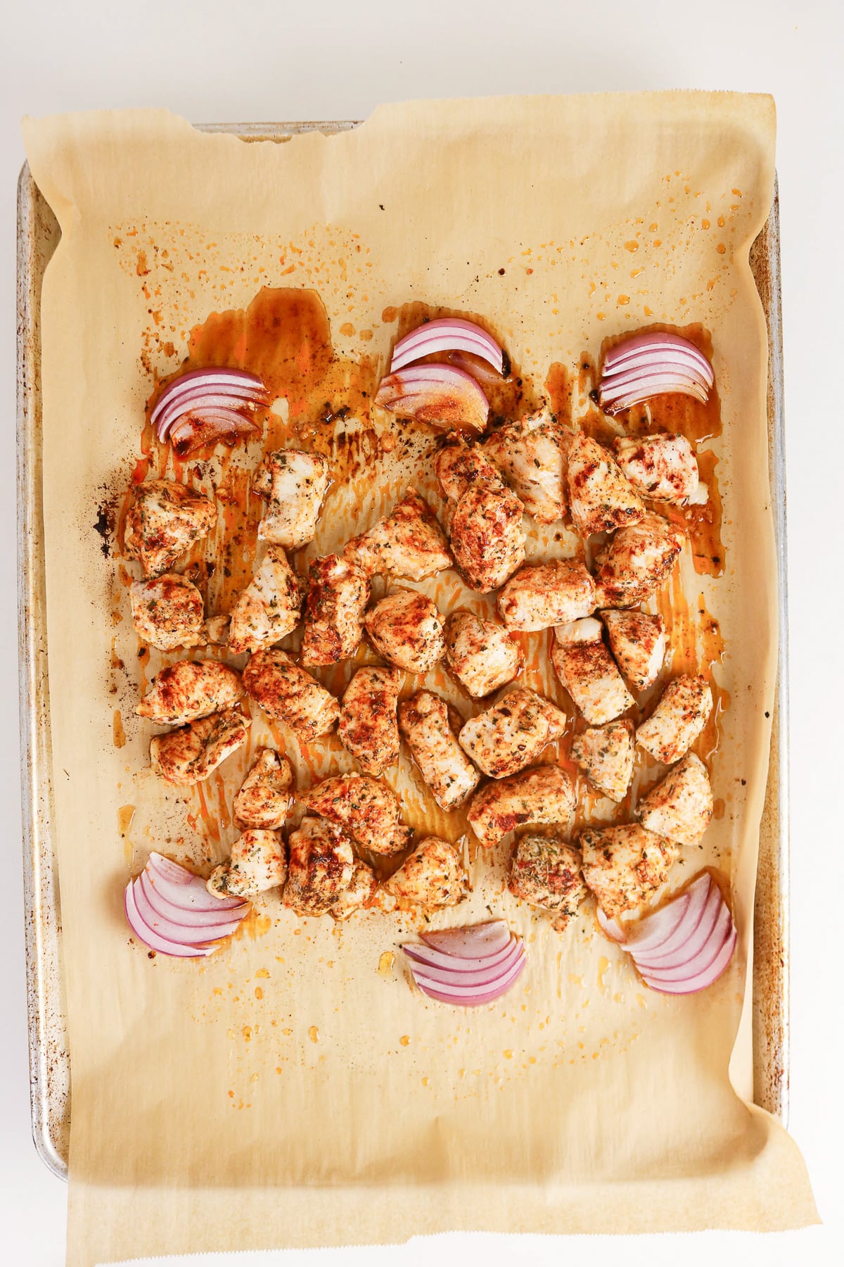 Roasted chicken on sheet pan, ready to add the veggies.