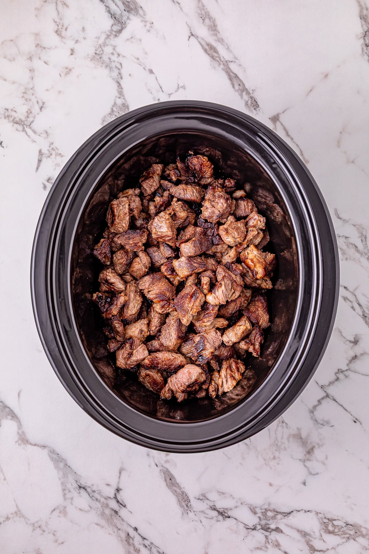 Seared meat in bottom of crockpot.
