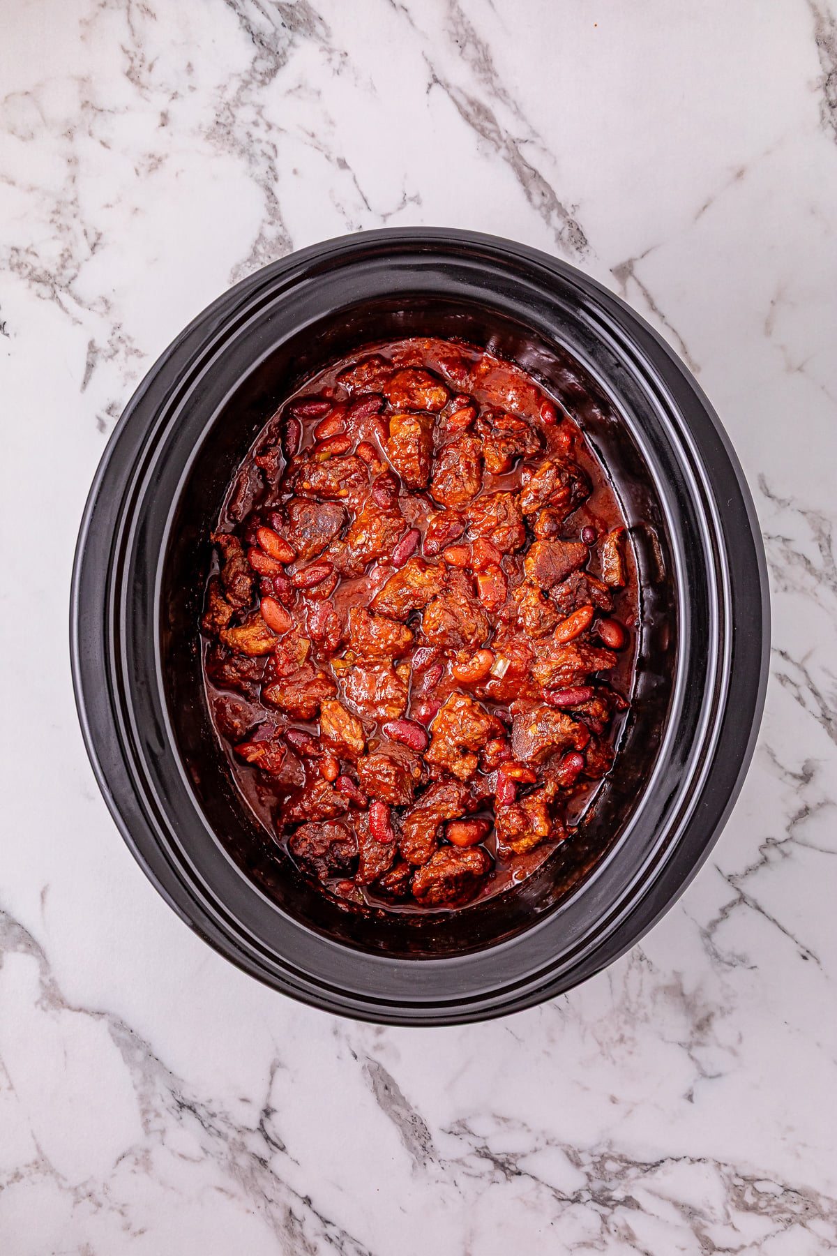 Steak chili con carne in crockpot ready to be cooked.